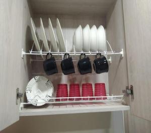 a shelf with plates and utensils in a kitchen at Céntrico Familiar Vive y disfruta Medellín 107 in Medellín +14 photos