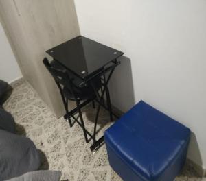 a black table and a blue stool in a room at Céntrico Familiar Vive y disfruta Medellín 107 in Medellín