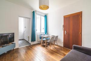 a living room with a couch and a table at Le Charmant Bacquenois in Reims