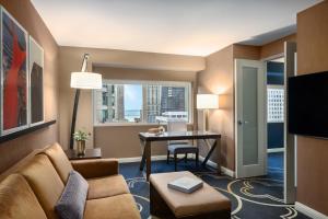 a living room with a couch and a desk and a window at Omni Chicago Hotel in Chicago