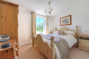 a bedroom with a large bed and a window at Bethel Cottage in Lyme Regis