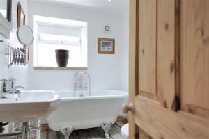 a bathroom with a white tub and a sink at Bethel Cottage in Lyme Regis +19 photos