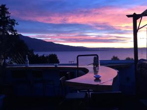 a table on a balcony with a view of the water at Rooftop Loft with Hydromassage in Volos