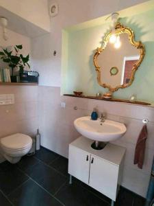 a bathroom with a sink and a toilet and a mirror at Meerzeitraum Ferienwohnung in Neustadt in Holstein