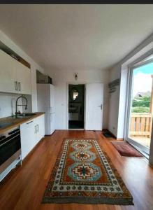 an empty kitchen with a rug on a wooden floor at Meerzeitraum Ferienwohnung in Neustadt in Holstein +12 photos