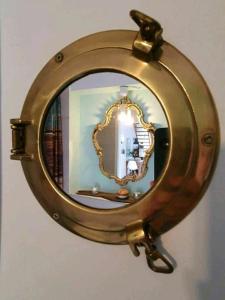 a gold mirror hanging on a wall at Meerzeitraum Ferienwohnung in Neustadt in Holstein