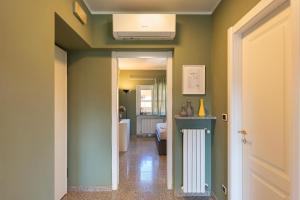 a hallway with a room with green walls and a radiator at Casa del Corso in Novi Ligure +8 photos
