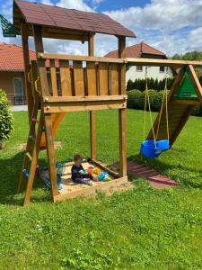 a little boy playing in a sandbox in a play house at Pimkie Apartman in Zalakaros