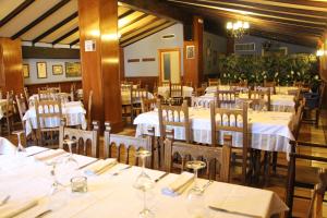 a restaurant with tables and chairs with white tablecloths at Aparthotel Tres Caminos in El Grado
