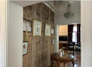 a living room with a table and a wall with wood at Crystal Apartament in Lublin