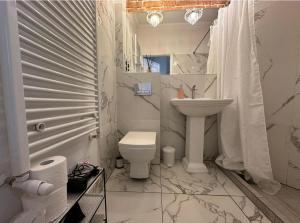 a white bathroom with a toilet and a sink at Crystal Apartament in Lublin