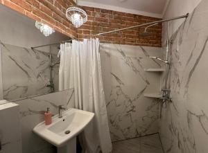 a white bathroom with a sink and a shower at Crystal Apartament in Lublin