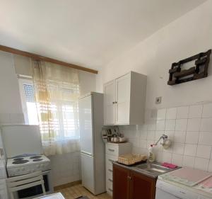 a kitchen with a white refrigerator and a sink at Sunlit City Apartment Gjakova in Gjakove +6 photos
