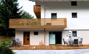 a house with a deck with a dog sitting under it at Studio Marjetica in Zgornje Gorje