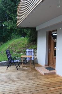 a patio with a table and chairs on a deck at Studio Marjetica in Zgornje Gorje +5 photos