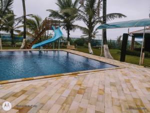 a slide in the middle of a swimming pool at Colônia Virtual Net in Itanhaém
