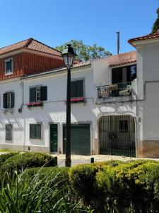 a white house with a street light in front of it at Jardim de Cascais in Cascais