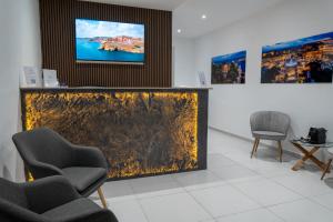a waiting room with chairs and a tv on the wall at The Republic Boutique Hotel in Valletta