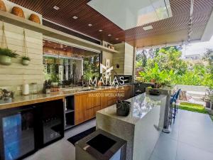 eine Küche mit Spüle und Theke in der Unterkunft Luxuosa Casa 5 Suítes, Piscina e Jacuzzi - Riviera in Bertioga