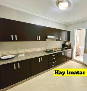 a kitchen with brown cabinets and a counter top at Appartement in Nador in Nador +11 photos