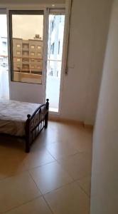 a bedroom with a bed and a large window at Appartement in Nador in Nador