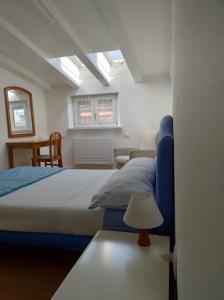 a bedroom with a bed and a table with a lamp at cairoli7novate-mansarda in Novate Milanese