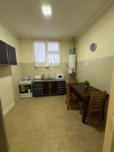 a kitchen with a table and a stove and a sink at Hotel Paris in Río Gallegos