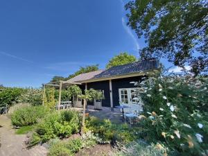 a cottage in the garden with flowers at Logeren bij De Soerensesteeg in Uddel