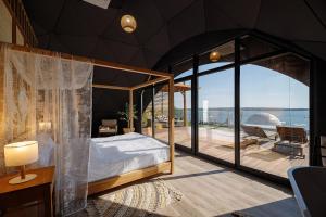 een slaapkamer met een hemelbed en een balkon bij SIRKA SPACE Hotel in Tsetula +162 foto's