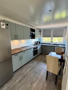 a kitchen with white cabinets and a table in it at Weitblick in Itzehoe +3 photos