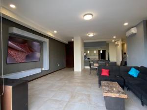 a living room with a couch and a flat screen tv at DEPARTAMENTO DE LUJO muy AMPLIO in Tampico