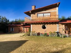 a large brick house with a porch and a window at Cabañas Los Saucos in Valle de Bravo