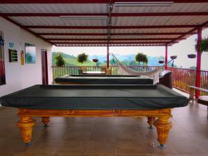 two pool tables on a porch with a hammock at Finca Hotel Villa Clara in Chinchiná