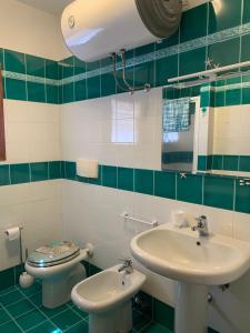 a bathroom with a sink and a toilet at Casa Abbilone - giardino privato in Santa Teresa Gallura +15 photos