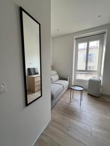 un soggiorno con un divano e uno specchio di Studio Sydney - Jean Médecin - LA RIVIERA LCD a Nizza