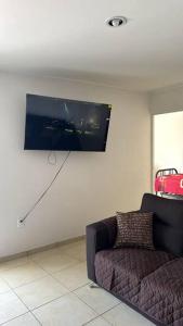 ein Wohnzimmer mit Couch und Flachbildfernseher in der Unterkunft departamento en yecapixtla in Tecolote