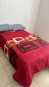 ein Bett mit einer roten Decke darüber in der Unterkunft departamento en yecapixtla in Tecolote