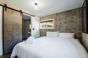 ein Schlafzimmer mit einem großen Bett und einer Ziegelwand in der Unterkunft The Cottage by Wanderlust Abodes in Bellaire + 70 Fotos