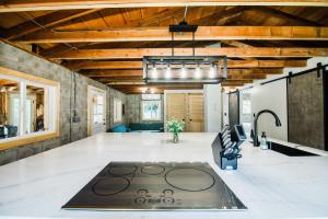 ein großes Wohnzimmer mit Holzdecken und einem Ofen in der Unterkunft The Cottage by Wanderlust Abodes in Bellaire