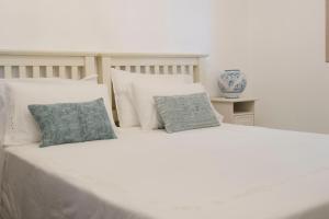 a large white bed with two pillows on it at Tancredi's Seaside Home in Granelli