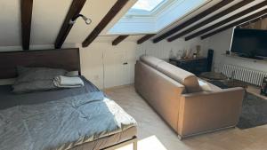 a bedroom with a bed and a couch and a television at Urlaub im Schwarzwald in Lenzkirch