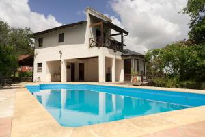 a villa with a swimming pool in front of a house at Casa La Selva in Sierra de los Padres