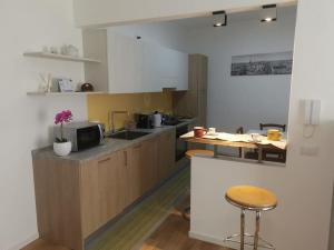 a kitchen with a counter and a table with a vase of flowers at Open Space in Bassano del Grappa