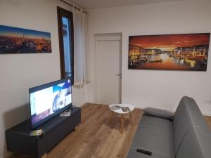 a living room with a couch and a flat screen tv at Open Space in Bassano del Grappa