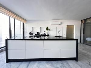 a kitchen with white cabinets and a black counter top at Playablanca Luxury Beach Apartment First Floor in Tanger in Tangier