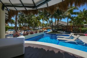 a pool at the resort with chairs and palm trees at El Dorado Casitas Royale, All & More Inclusive - Adults Only in Puerto Morelos