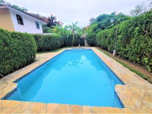 a large blue swimming pool in front of a house at Linkzup Playa Laguna Villa in Sosúa