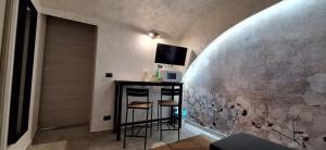 een kamer met een bar met een tv aan de muur bij Lilly apartment in Catania