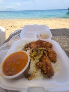 a plate of food with rice and a bowl of soup at Linkzup Playa Laguna Villa in Sosúa