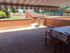 a patio with a table and a bench and a brick wall at Apartamento Montecanal 5 in Jaca